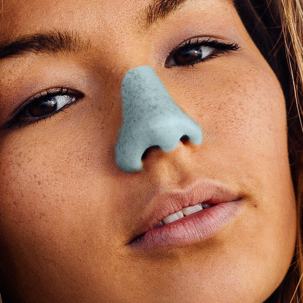 Woman posing with blue Nözscreen on her nose.